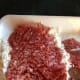 Lay the cube steak on top of the flour to start breading.