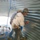 2 punches are necessary, and 3 can be handy. You may need to work your way across the sheet, pinning and bracing it until someone outside can get a bolt in, then pinning it using further holes, sliding and bracing it into alignment all the way across