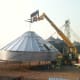 We are using a large forklift to lift the bin, in place of grain bin jacks. This is bin #2 of two identical bins featured in this article. It is being built on an open patch of driveway, and has just been lifted in order to add ring #2.