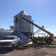 Due to a slight breeze and the need for stable ground for ladder use under the roof, this bin is being erected on the concrete slab close to a sheltering building.