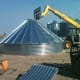 With a forklift, boom truck, and crane, you may set the boom against the peak while pausing during construction, to ensure your bin doesn't blow away.