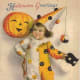 Free vintage Halloween card: little boy clown with pumpkin