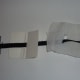 Adding the tapes is quite complicated. Here you can see there is a tag, a piece of card and a piece of gauze to make the fastening.