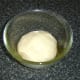 Kneaded pizza dough is added to an oiled bowl