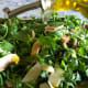 Pouring extra virgin olive oil over the salad