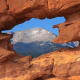 Pikes Peak mountain, America's Mountain, through the red rocks of the Simese Twins rock formation in Garden of the Gods park located in Colorado Springs, CO.