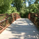 The overhead bridge entrance to the Four Mile Creek Greenway. This bridge goes over a creek.