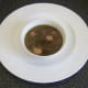 Coq au vin soup is ladled in to a serving bowl