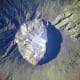 A detailed astronaut photograph depicting the summit caldera of the volcano Mount Tambora, Indonesia