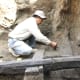 Excavating carbonized building beams (Photograph: Made Wita)