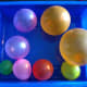 Blow up 8 water balloons in sizes to represent the planets. Blow up a larger balloon for the Sun.