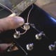 Do one turn around the peg, then insert string through hole.