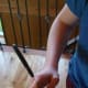 Step 12: Inserting the wire hanger under the round plastic ring on pop bottle mouth.