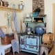 By adding simple elements like vintage aprons, you add a 50's vibe to your kitchen. A cast iron stove helps, too.