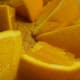 Add the wedged and quartered oranges to the pitcher or bowl.
