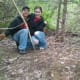 Two happy mushroom hunters surrounded by big yellow morel mushrooms.