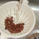 Canned borlotti beans are rinsed under running cold water