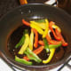 Frying bell peppers and garlic in olive oil