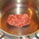 Ground/minced beef is added to dry pot
