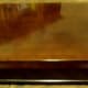 Our solid wood chest is heavy. Raised with only the four corners touching the table or surface. It is smooth with a glossy finish.