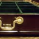 Gold plated hinged handles on both sides. It's only a few inches tall.
