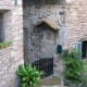 A terra cotta-type plaque of Madonna and child attached to a bricked up door next to a small light.