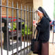 A Franciscan nun lighting a vigil candle at the shrine near the entrance of San Damiano.