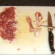 Tendons are snipped from duck leg meat with scissors