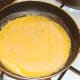 Beaten duck eggs added to omelette pan
