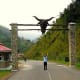 A tourist raising hands in front of the entrance of Obudu Cattle Ranch in Calabar, Nigeria
