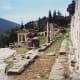 The first switchback of the Sacred Way with Treasury of the Athenians in the distance, the Lesbian Wall at right.