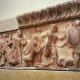 The North Frieze of the Siphnian Treasury shows a Gigantomachy, a battle between the gods and the Titans representing the victory of order over chaos. At left, Hera bends to finish off a giant under the horses of Zeus' chariot, then Athena takes on t