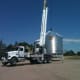 We still used caution and guide ropes while moving this bin across a big driveway to the site on which the hopper was built. Here the crane is slowly bringing the bin in close to the rear of the cab, with all outriggers extended.