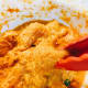 Place coated chicken pieces into the pan gently, using tongs, to avoid splashing oil.