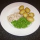 Poached chicken leg meat with new potatoes and peas