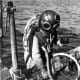 Sponge diver on edge of boat with sponge - Tarpon Springs