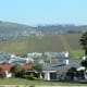 View of some Dutch Colonial style buildings and farmland. In the distance you can see Table Mountain.