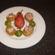 Seared partridge breasts on fondant potatoes with a cranberry juice poached pear