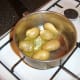 Butter and dill are added to the drained potatoes while the pie topping is toasting