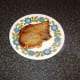 Pork chop is transferred to a heated plate to rest while the egg is fried
