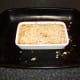 Cheese and breadcrumbs are scattered on top of the pie