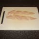Whiting fillet is chopped in to pieces for fish pie