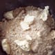 Pour the topping mixture over the apples. Top with spoonfuls of butter and squirt the other half of the lemon out onto the topping.