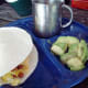 Enjoy your breakfast burrito with a side of avocado and a warm morning drink.