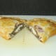 Pasty is carefully halved on chopping board