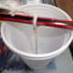 Tying and supporting the wick at the top of the cup