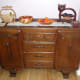 A family of wooden fruit bowls on the sideboard packed with fruit and nuts