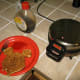 Remove the waffle and use a damp cloth or paper towel to clean.