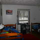 The boys' bedroom before the transformation: drab, white walls and uncoordinated bedding.