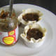 Mincemeat is carefully spooned in to pie casings in ramekins